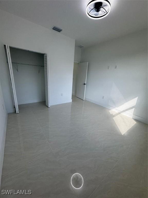 unfurnished bedroom with a closet and visible vents