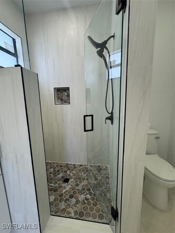 bathroom featuring toilet and an enclosed shower