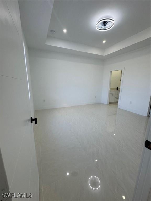 spare room featuring a raised ceiling and recessed lighting