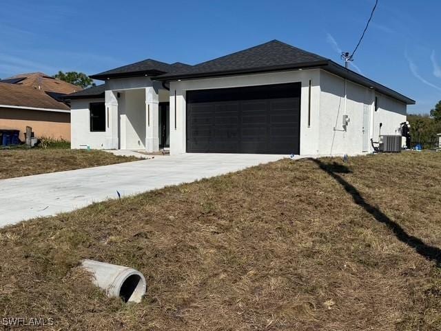 view of front facade featuring a garage, central AC unit, concrete driveway, and stucco siding