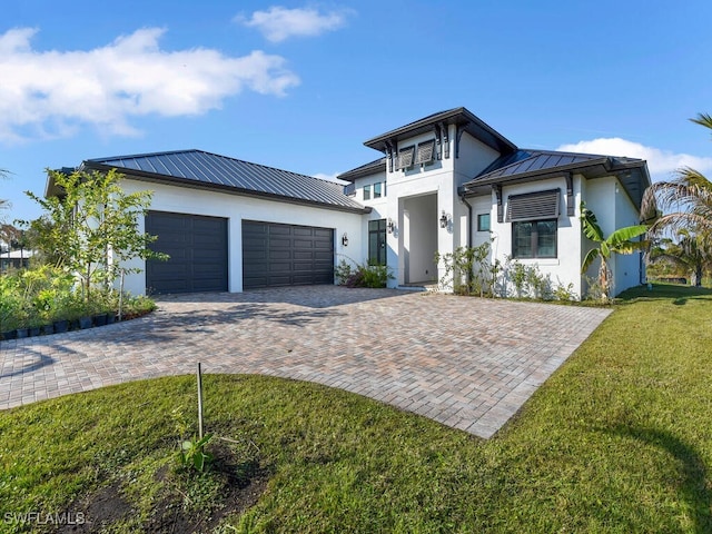 view of front of house featuring a garage and a front lawn