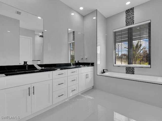 bathroom featuring vanity, tile patterned flooring, and a washtub