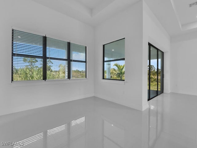 spare room featuring a raised ceiling and tile patterned floors