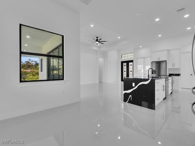 kitchen featuring ceiling fan, kitchen peninsula, stainless steel dishwasher, and white cabinets