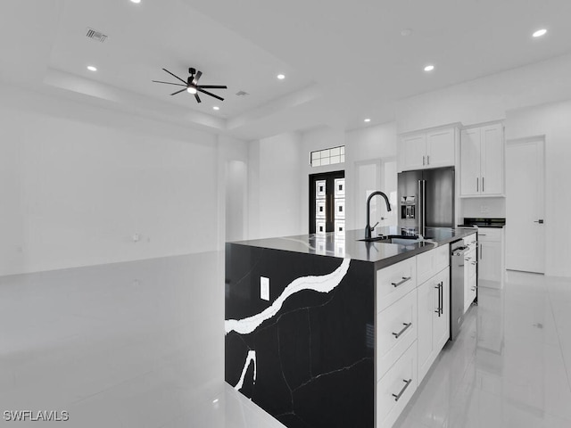 kitchen featuring stainless steel dishwasher, white cabinets, a tray ceiling, and high quality fridge