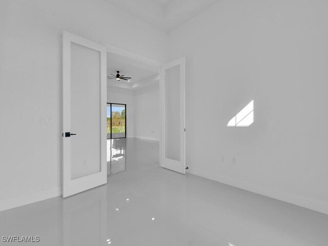 empty room featuring ceiling fan and french doors