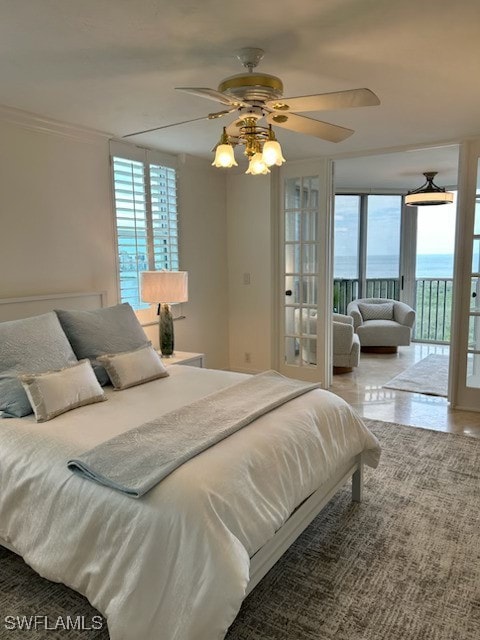 bedroom featuring a water view, access to exterior, a ceiling fan, and crown molding