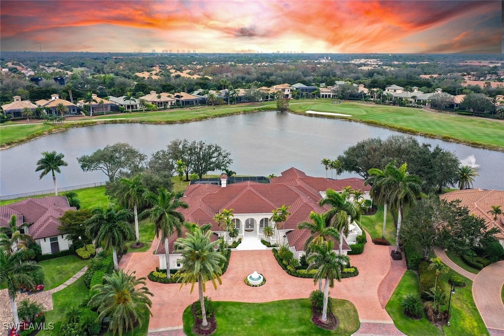 aerial view at dusk featuring a water view