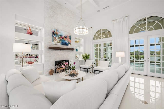 living room with a towering ceiling, a fireplace, and french doors