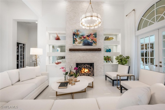 tiled living room featuring built in features, a stone fireplace, and a chandelier