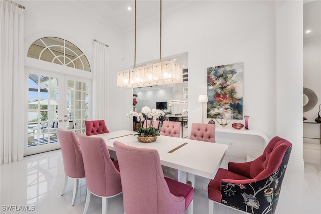 dining space with a high ceiling, ornamental molding, and french doors