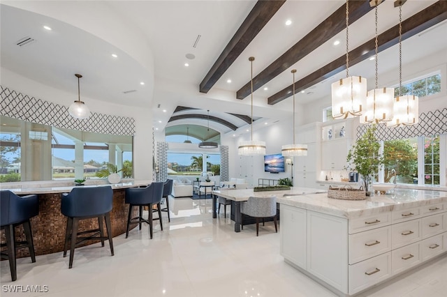 kitchen featuring decorative light fixtures, white cabinetry, and a large island