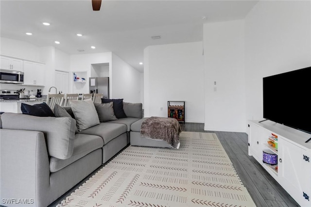 living room featuring ceiling fan and light hardwood / wood-style flooring