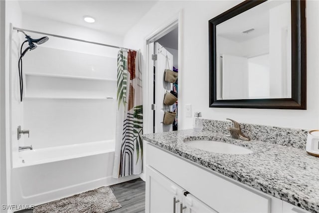 bathroom with wood-type flooring, vanity, and shower / tub combo with curtain