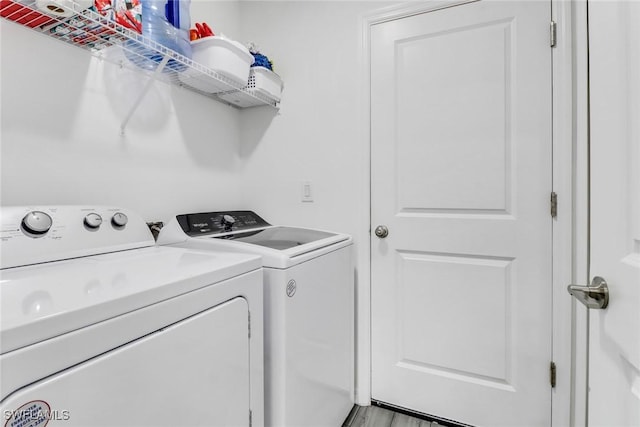 laundry area with light hardwood / wood-style floors and separate washer and dryer