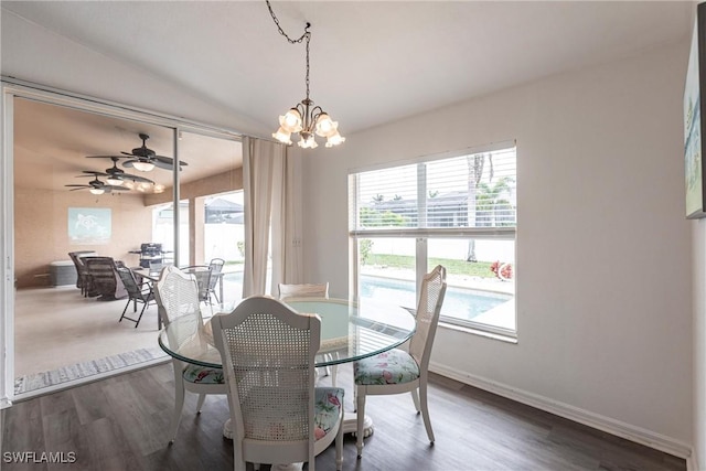 dining area with ceiling fan with notable chandelier, plenty of natural light, and dark hardwood / wood-style flooring