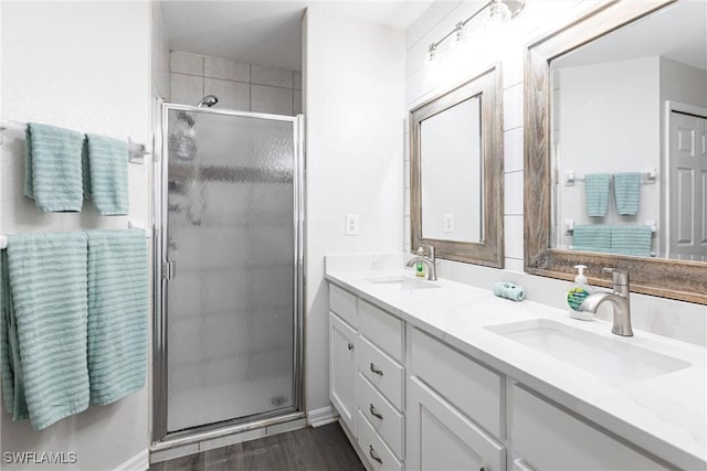 bathroom featuring vanity, wood-type flooring, and a shower with door