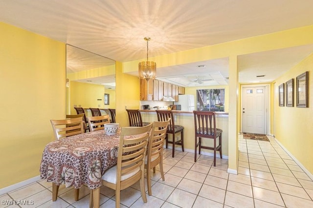 tiled dining room with an inviting chandelier