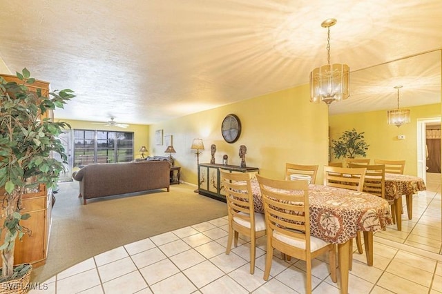 dining room featuring ceiling fan with notable chandelier and light colored carpet