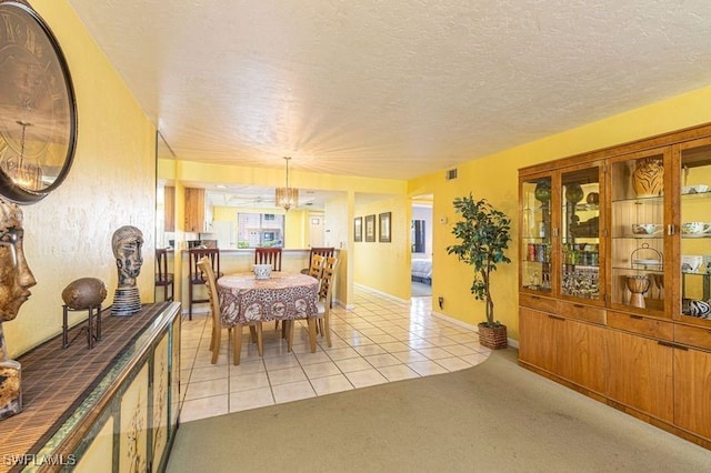 carpeted dining area with an inviting chandelier and a textured ceiling