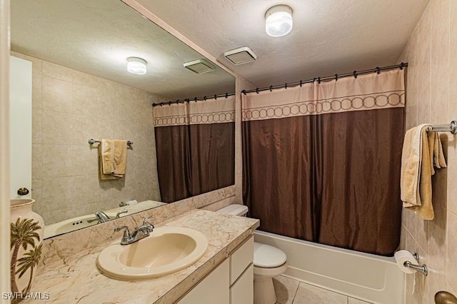 full bathroom with tile patterned floors, shower / bathtub combination with curtain, vanity, and tile walls