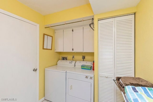 laundry room with washer and dryer and cabinets