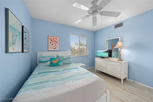 bedroom with light wood-style flooring, a ceiling fan, visible vents, and baseboards