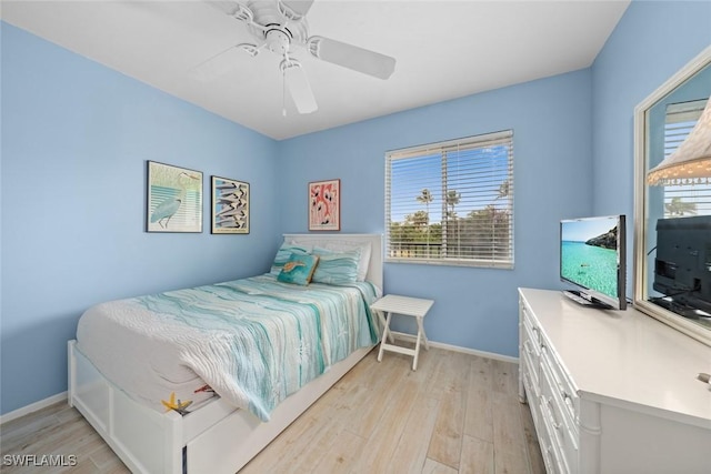 bedroom with light wood-type flooring, baseboards, and a ceiling fan