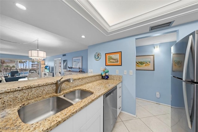 kitchen with a sink, visible vents, white cabinets, appliances with stainless steel finishes, and decorative light fixtures