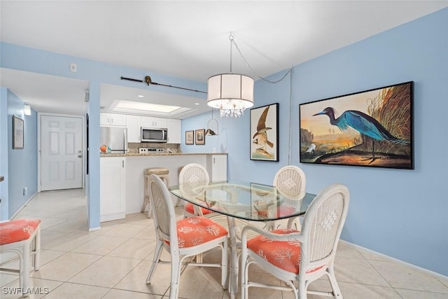 dining area with light tile patterned floors, an inviting chandelier, and baseboards