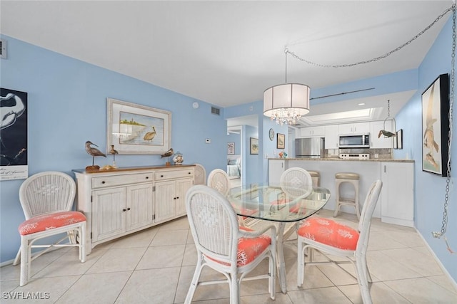 dining area with light tile patterned floors, visible vents, and an inviting chandelier