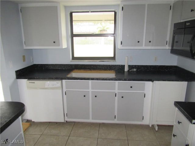 kitchen featuring white cabinets, light tile patterned flooring, and white dishwasher