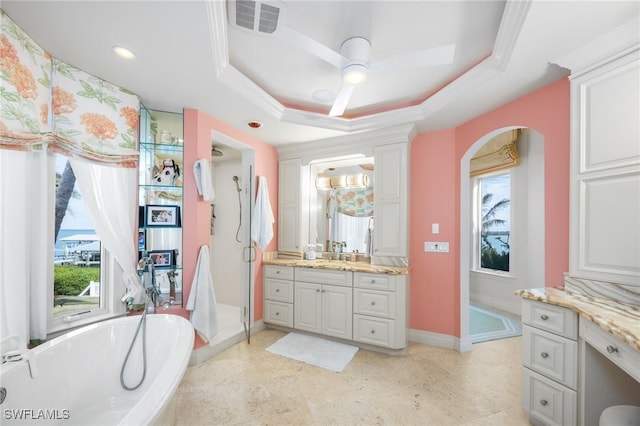 bathroom with a healthy amount of sunlight, a raised ceiling, and vanity