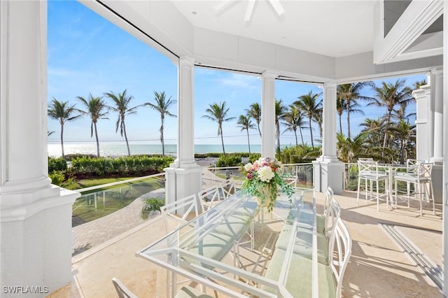 sunroom featuring a water view