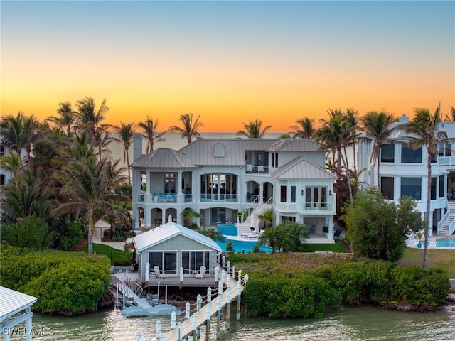 back house at dusk featuring a water view