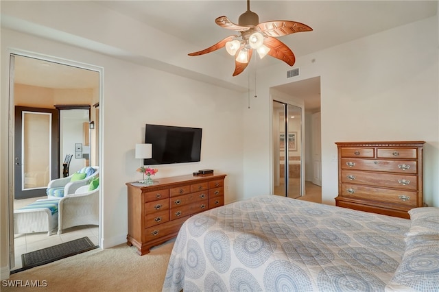 bedroom with ceiling fan, light colored carpet, and a closet