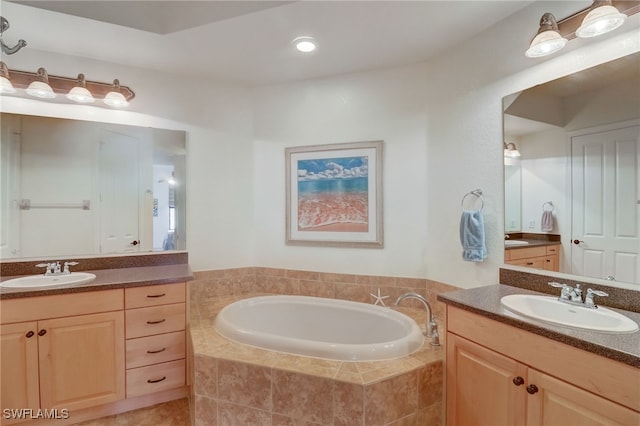 bathroom with tiled bath and vanity