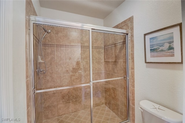 bathroom featuring toilet and an enclosed shower