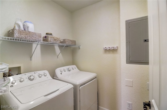 clothes washing area with separate washer and dryer and electric panel