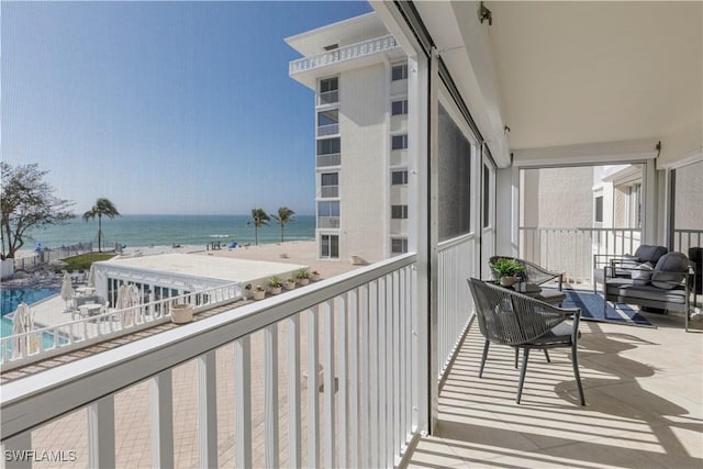 balcony with a water view and a view of the beach