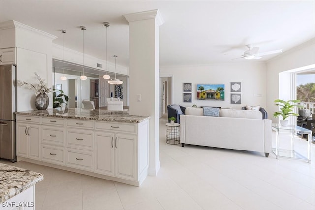 kitchen featuring pendant lighting, stainless steel fridge, ceiling fan, ornamental molding, and light stone countertops