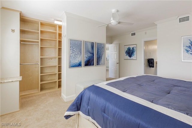 carpeted bedroom with crown molding, ceiling fan, and a closet