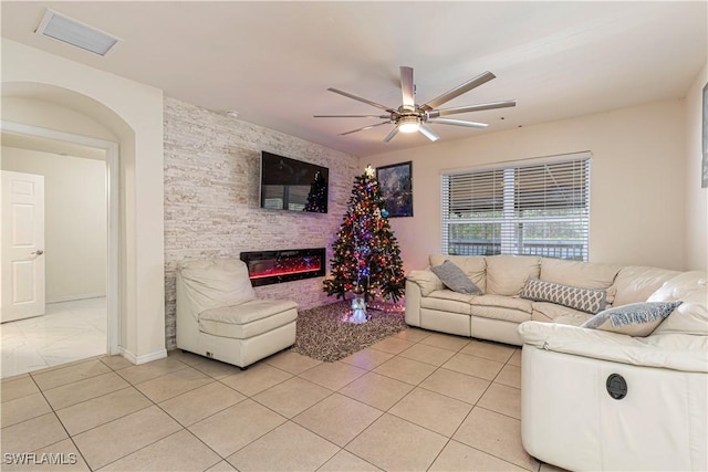 unfurnished living room with ceiling fan, light tile patterned floors, and a fireplace