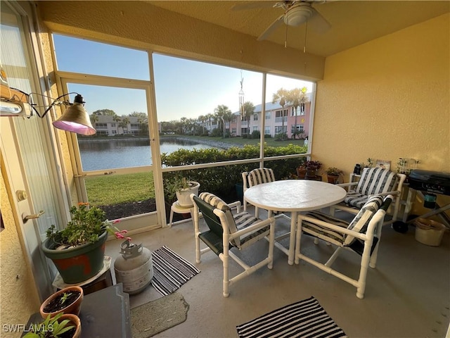 sunroom with a water view, ceiling fan, and plenty of natural light