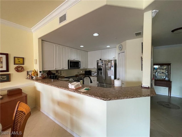 kitchen featuring kitchen peninsula, white cabinetry, ornamental molding, stainless steel appliances, and light tile patterned floors