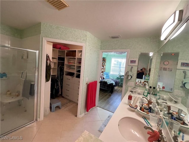 bathroom featuring tile patterned floors, an enclosed shower, and vanity