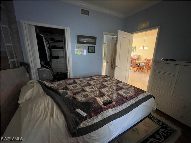 tiled bedroom featuring a closet and crown molding