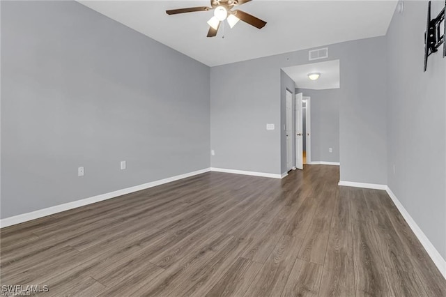 spare room featuring ceiling fan and dark wood-type flooring