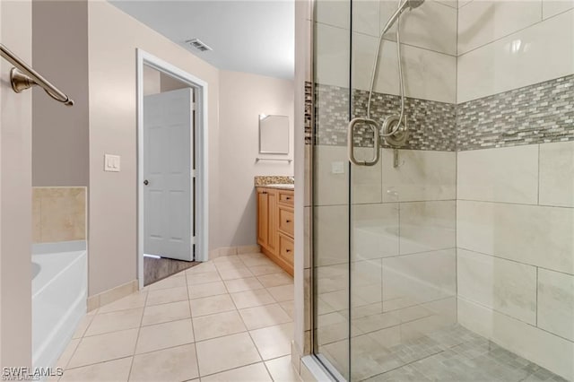 bathroom with plus walk in shower, tile patterned floors, and vanity