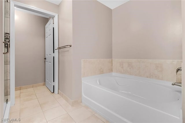 bathroom with tile patterned flooring and a tub to relax in